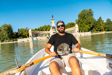 A tourist rowing the boat in the Estanque Grande de El Retiro in the city of Madrid. Spain