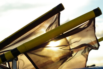 Czarne flagi rybackie na tle wschodzącego słońca - obrazy, fototapety, plakaty