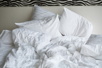 Bed with soft pillows and white sheets. White bed set