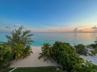 Foto op Plexiglas Seven Mile Beach, Grand Cayman Een luchtfoto van Cemetery Beach op Seven Mile Beach in Grand Cayman Island met een prachtige zonsondergang.