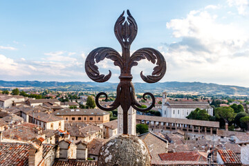 Vintage fleur-de-lys made of cast iron and the old center of Gubbio in the background, Umbria, Italy, Europe