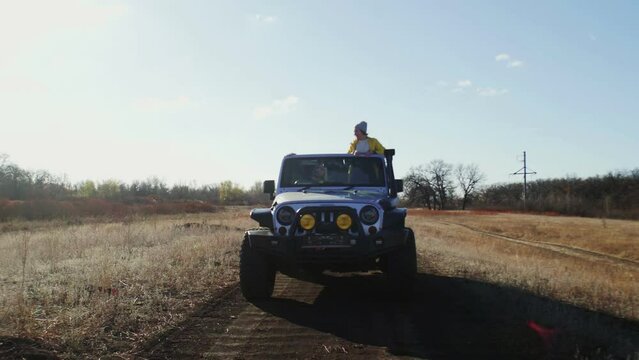 Young women drives 4x4 off road vehicle jeep on country road