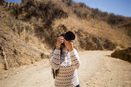 mujer turista tomando fotos con una cámara dslr profesional. Concepto de viajes, turismo y estilos de vida.