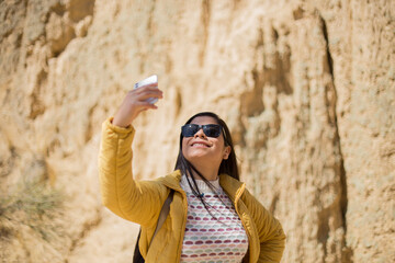 Mujer turista tomando selfies con su teléfono en un cañon. Concepto de turismo, viajes, vacaciones