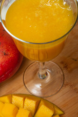 .delicious mango juice with mango pieces around