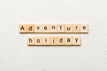 adventure holiday word written on wood block. adventure holiday text on cement table for your desing, concept