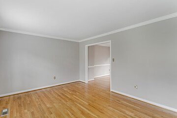 empty room with window grey walls hardwood floors white frame doorway