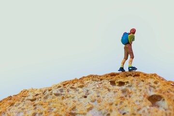 a hiker with a backpack stands on top of a slice of toasted bread