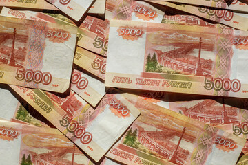 Banknotes of the Russian currency, an array of five thousand rubles with a close-up drawing. Scattered Russian ruble banknotes, money five thousand rubles. Scattered ruble banknotes, close-up view.