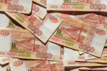 Banknotes of the Russian currency, an array of five thousand rubles with a close-up drawing. Scattered Russian ruble banknotes, money five thousand rubles. Scattered ruble banknotes, close-up view.