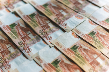 Banknotes of the Russian currency, an array of five thousand rubles with a close-up drawing. Scattered Russian ruble banknotes, money five thousand rubles. Scattered ruble banknotes, close-up view.