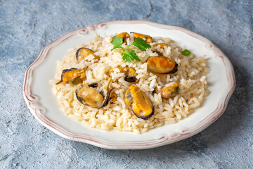 Mussel rice pilaf. Rice with mussels on small white plate on ceramic. (Turkish name; midyeli pilav)