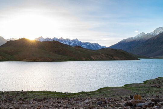 Beautiful view of Chandratal lake surrounded by mountains in India during a sunset