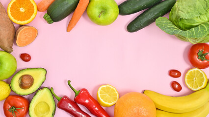 Healthy lifestyle frame with organic fruits and vegetables on pastel pink background. Flat lay copy space