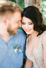 Bride and groom touch their foreheads to each other. Portrait