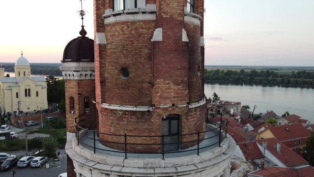 Drone zoom out of the tower, river and cityscape of Zemun in Belgrade, Serbia during sunset
