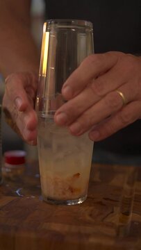 Vertical view of a man preparing caipirinha with lichia
