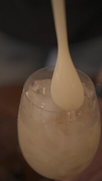 Vertical view of a man preparing caipirinha with lichia