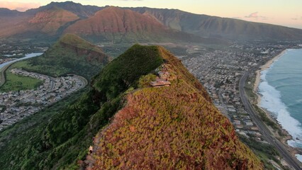 Aerial view of the Pink Pillbox hike route in Hawaii with gentle sea tides below at sunset