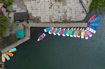 Top view of floating colorful boats docked on the pontoon