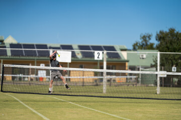 
Amateur playing tennis at a tournament and match on grass in Melbourne, Australia 
