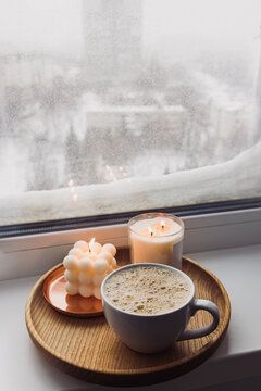 Cozy atmosphere winter still life with hot drink and candles on the windowsill