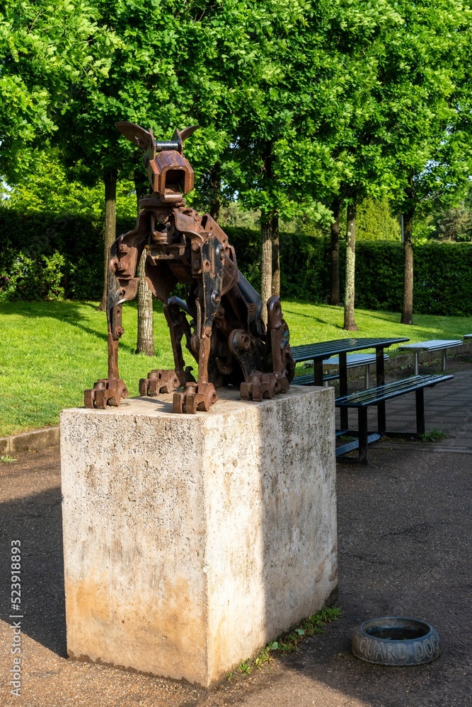 Wall mural vertical shot of a metal statue of a dog on a stone plinth in blaise castle estate, bristol