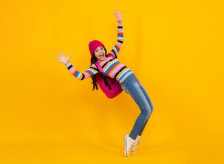 Autumn school. Teenager school girl with backpack in autumn clothes on yellow isolated studio background. Happy teenager, positive and smiling emotions of teen girl