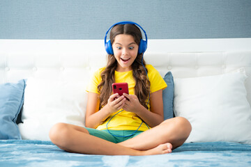 Surprised face, surprise emotions of teenager girl. Teenager child girl wearing headphones watching...