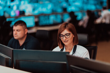 Female security operator working in a data system control room offices Technical Operator Working...