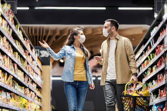 Couple purchasing groceries at supermarket during corona virus.