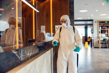 Check in at the hotel safely and without the risk of coronavirus. A specialist in a protective...