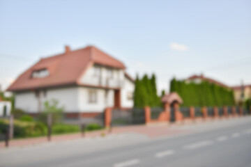 Fototapeta na wymiar Blurred view of suburban street with beautiful house