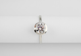 Beautiful engagement ring with gemstone on white background, top view
