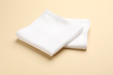 White handkerchiefs on beige background. Stylish accessory - obrazy, fototapety, plakaty