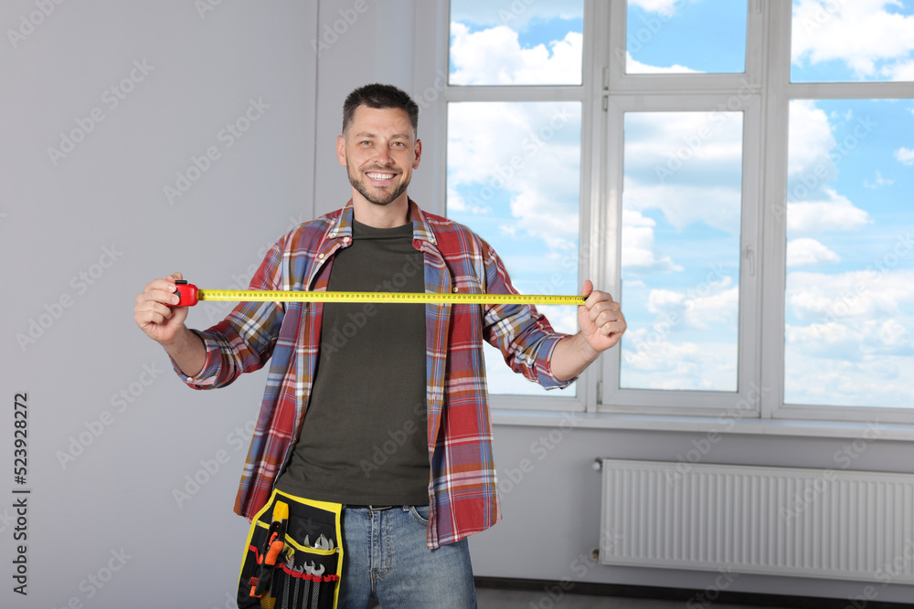 Sticker handsome worker with measuring tape in empty room