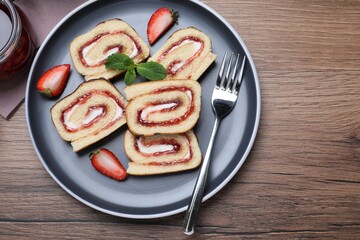 Tasty cake roll with strawberry jam and cream on wooden table, flat lay