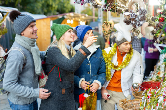 Family with two teenagers having fun on Christmas market . High quality photo