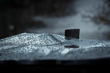 Beautiful closeup background of a snowdrift with a stump in it with gray and black sky at night