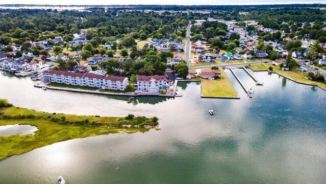 Chincoteague Island, marinas, houses and motels with parking lots. Road along the bay. Drone view.