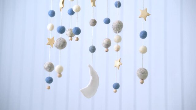Baby crib mobile. Toys above the baby crib. Hanging soft balls for the child.