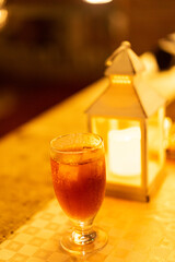 glass of iced tea and a lamp on the table