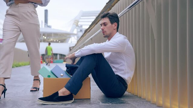Caucasian businessman sitting outdoor after unemployment from company. 