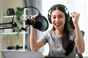 Asian attractive audio DJ woman speaks into microphone to broadcasting