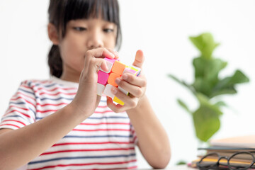 NAKHON RATCHASIMA, THAILAND - JULY 14, 2022:Asian little cute girl holding Rubik's cube in her...