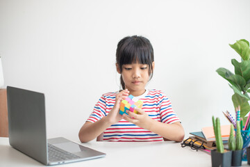 NAKHON RATCHASIMA, THAILAND - JULY 14, 2022:Asian little cute girl holding Rubik's cube in her...
