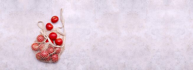 Large raw red tomatoes in a mesh bag