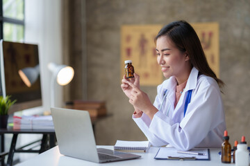 Asian female doctor discuss and discuss vaccine drug information and side effects with drug and vaccine specialists via video call in hospital.