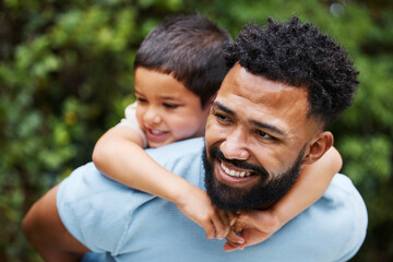 Fototapeta premium Happy father with son on piggyback while smiling, laughing and playing in a park outdoors. Cheerful, loving and caring dad relaxing, bonding and enjoying fun day with playful, cute and adorable boy