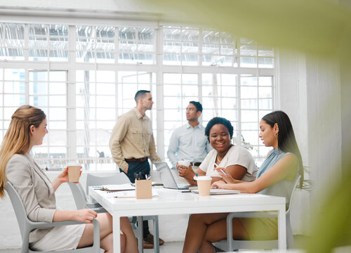 Happy, Smiling And Friendly Colleagues Talking On Their Coffee Break Or Meeting About The News And Gossip. Young, Global And Diverse Female Employees Enjoying Their Discussion In The Staff Room